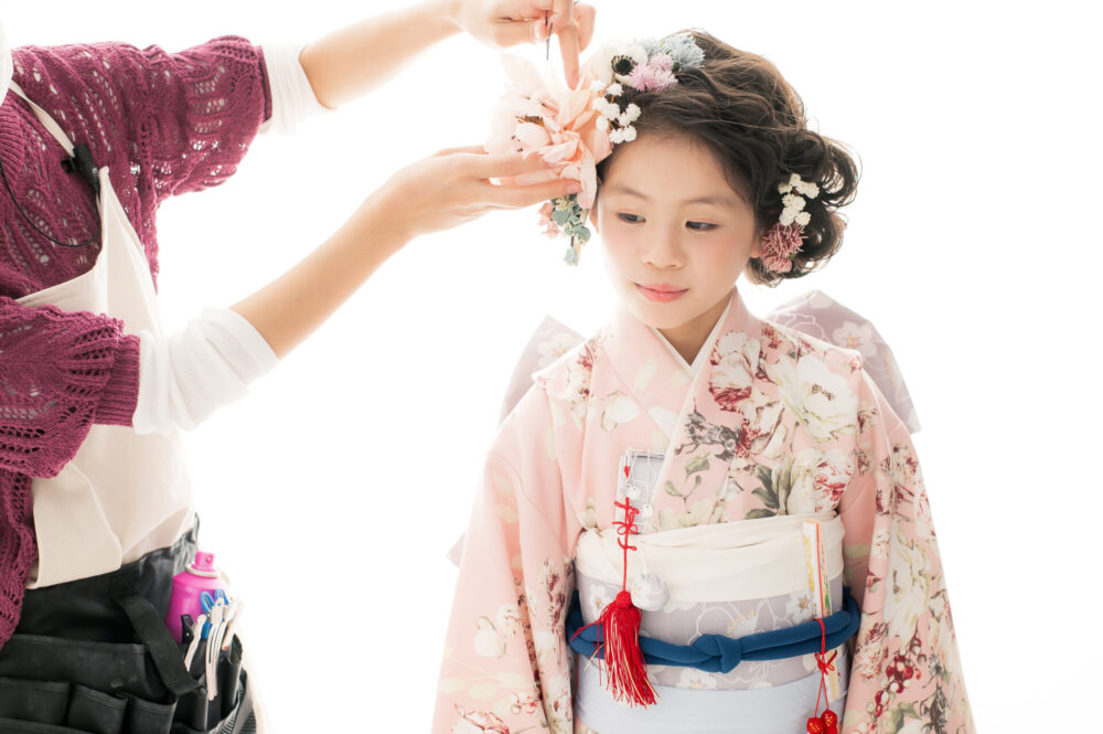 スタッフが七五三の女の子の髪飾りをつける様子
