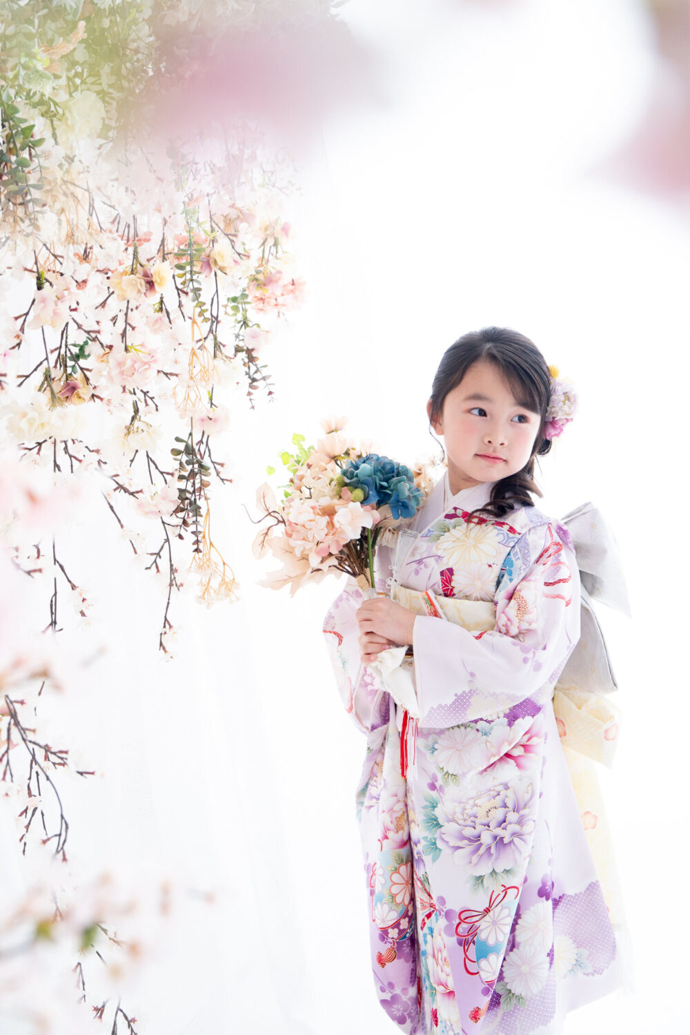 花束を持って振り向く7才の七五三の女の子