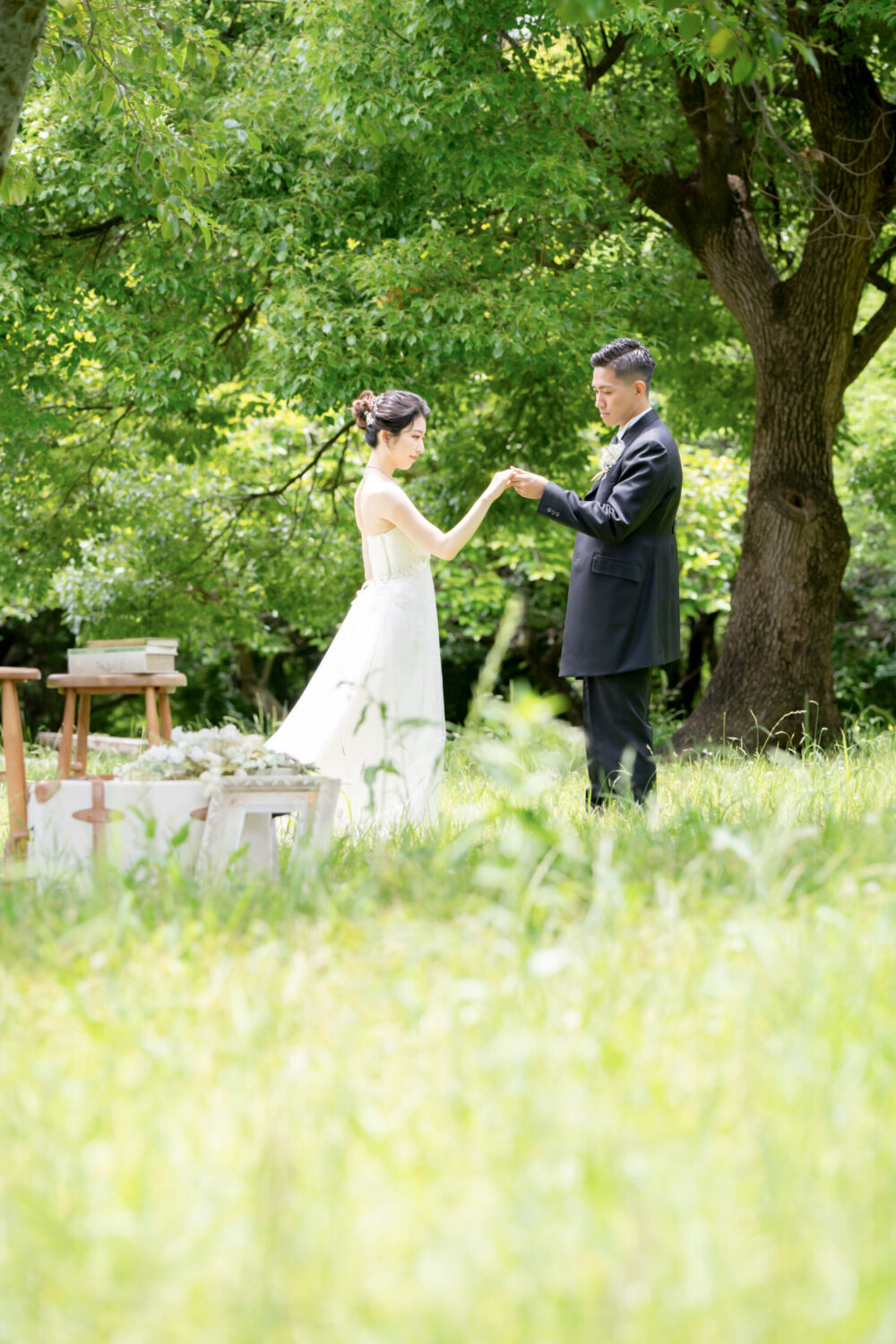 緑の芝生で手を取り合う新郎新婦