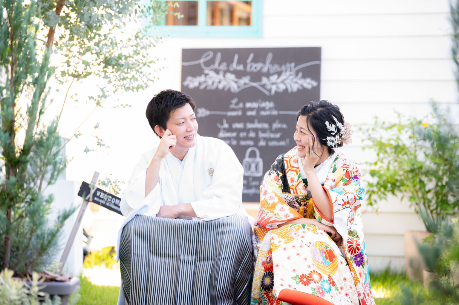 ガーデンで笑い合う紋付袴と色打掛の新郎新婦
