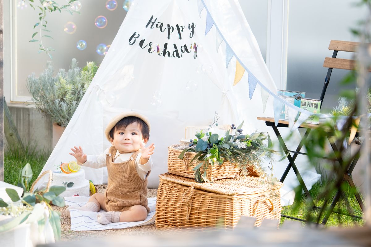 Happy Birthdayのテントの前に座る男の子