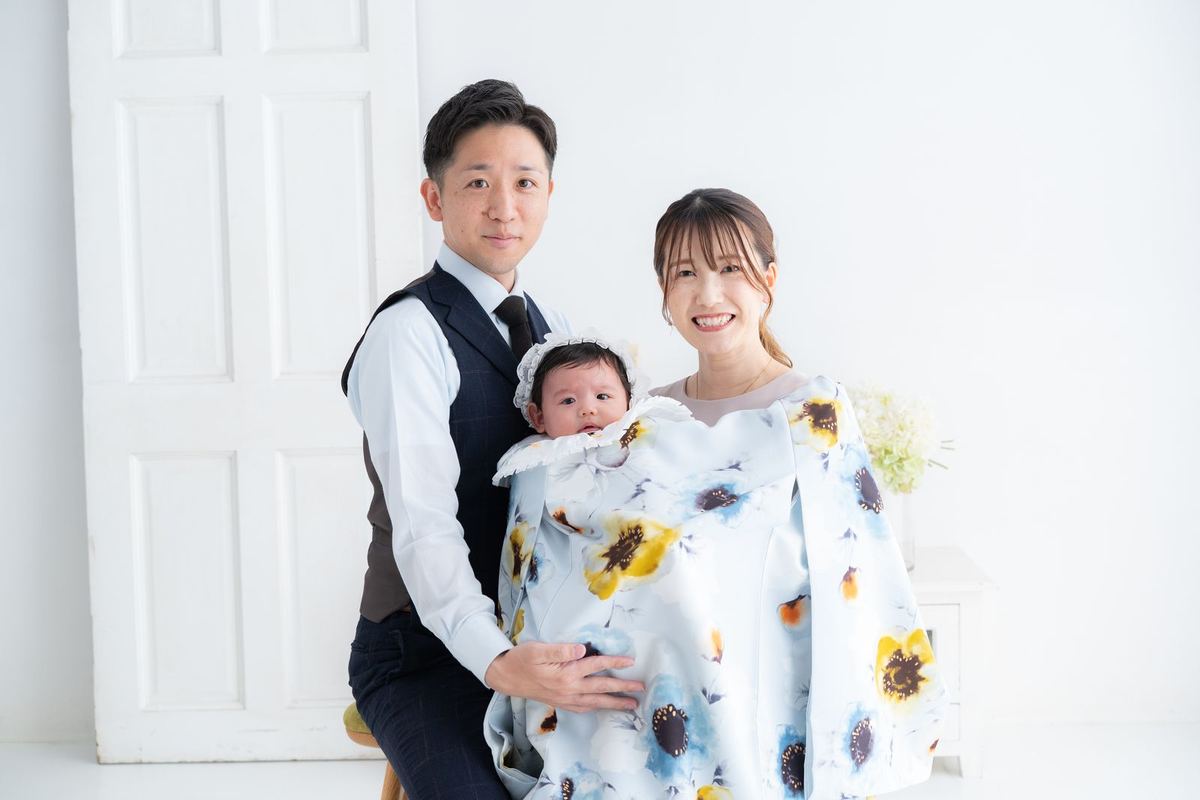 白いスタジオで晴れ着の赤ちゃんを抱く家族