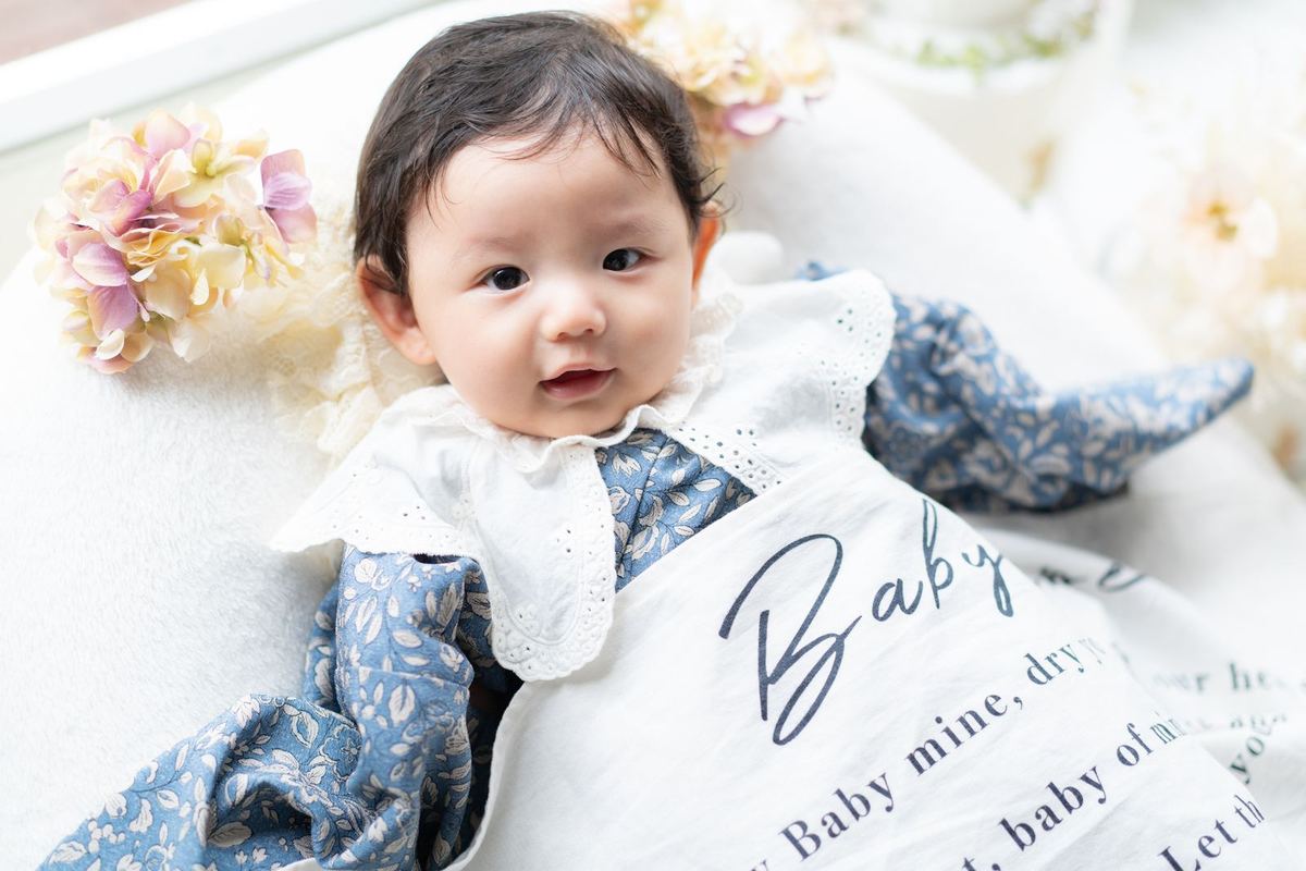 Baby mineのブランケットとブルーの晴れ着で見上げる赤ちゃん