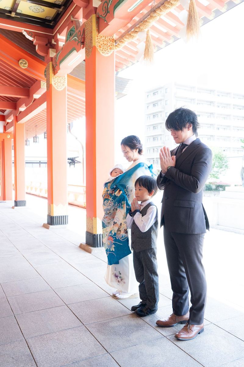 お宮参りで神社の回廊を歩く家族