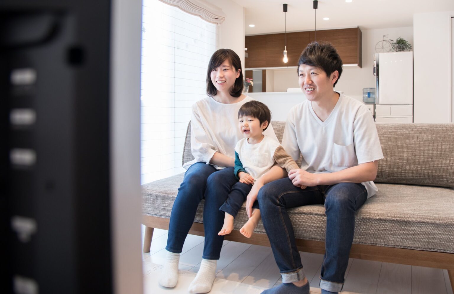 自宅のリビングでテレビを見る家族