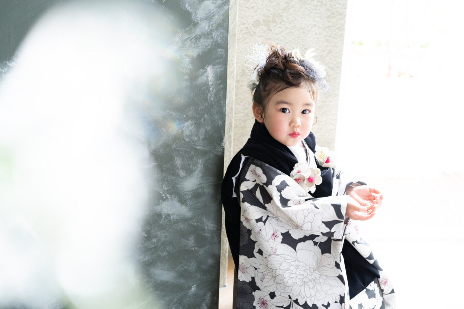 黒の着物で窓辺に立つ3才の七五三の女の子
