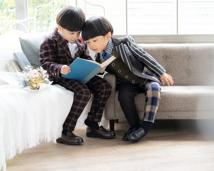 ソファで絵本を読む兄弟