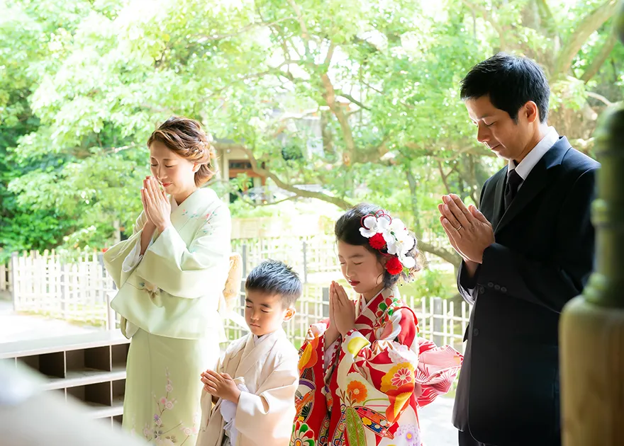 神社でお参りする七五三の家族