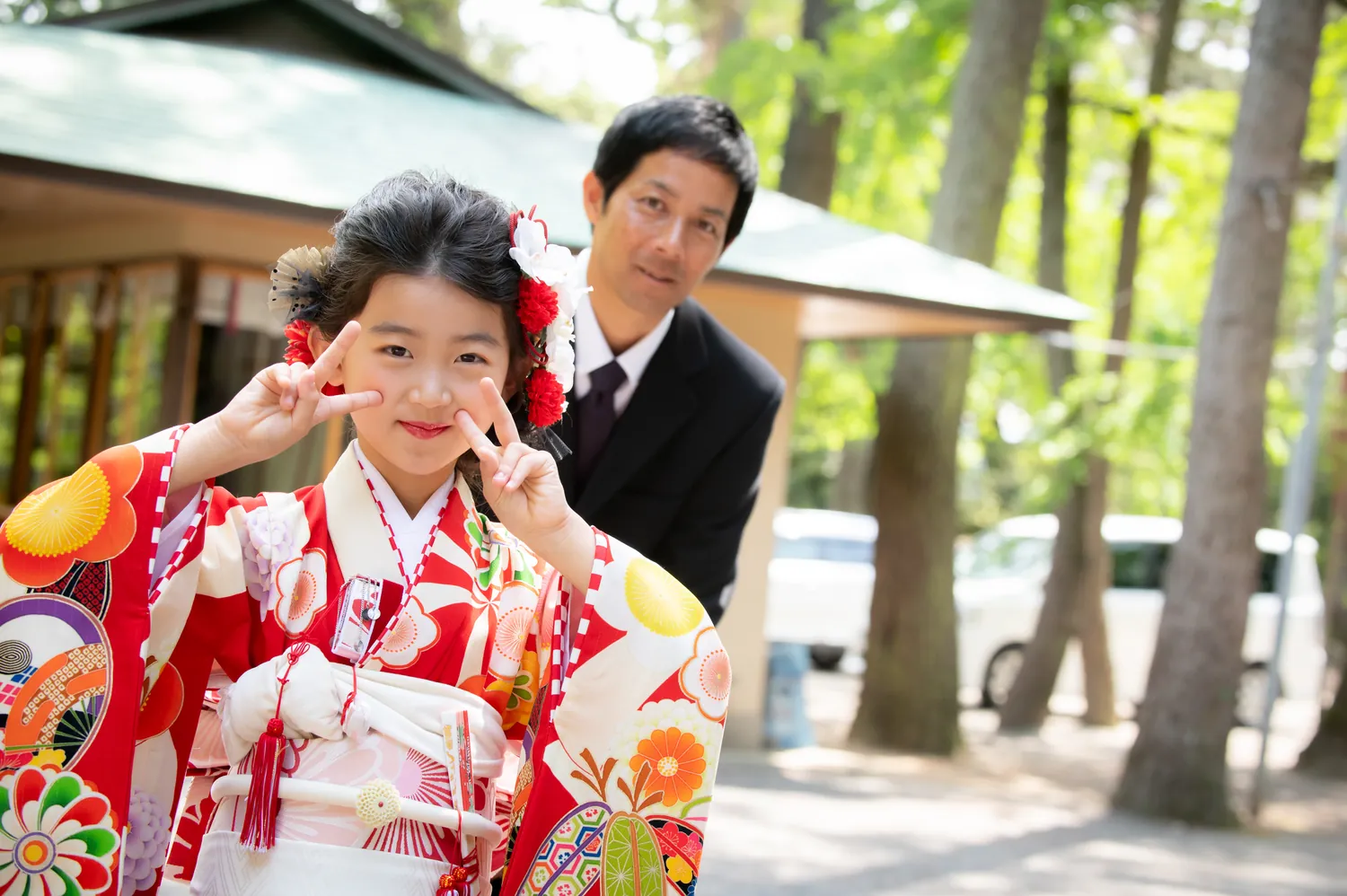ピースをする七五三の女の子とお父さん