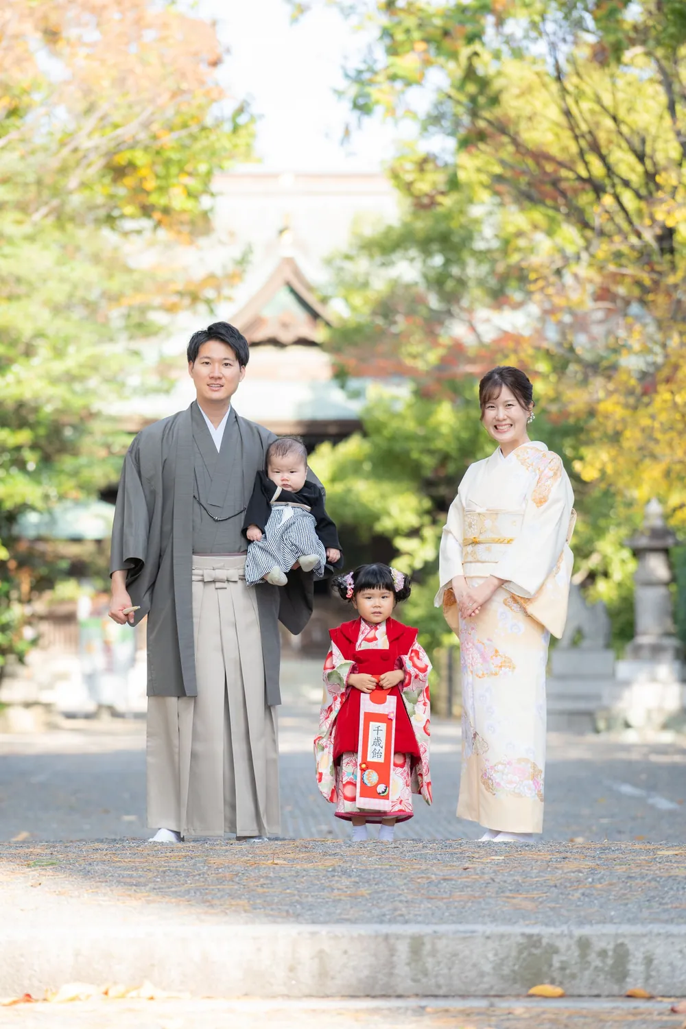 神社の境内で並ぶ着物姿の家族