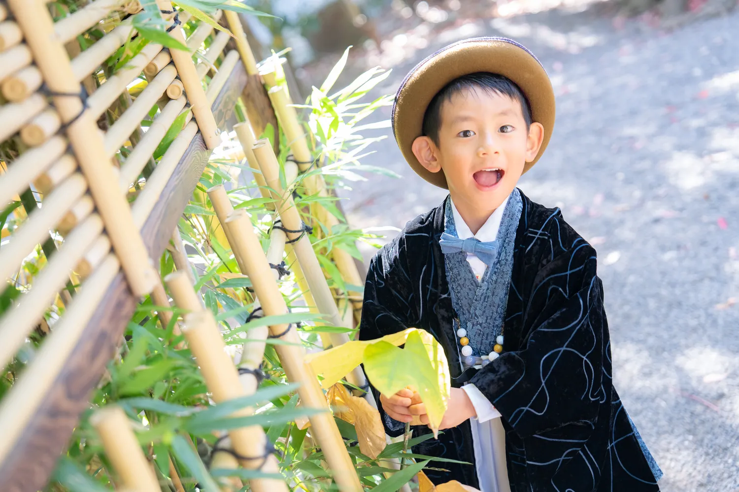 竹垣の前で笑う七五三の男の子