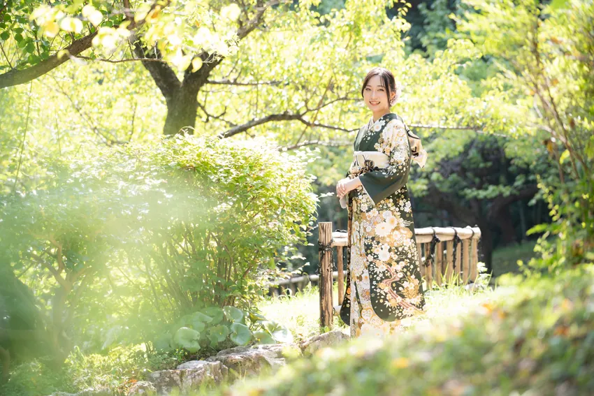 浜松城公園で、緑の庭園で深緑の振袖を着た女性