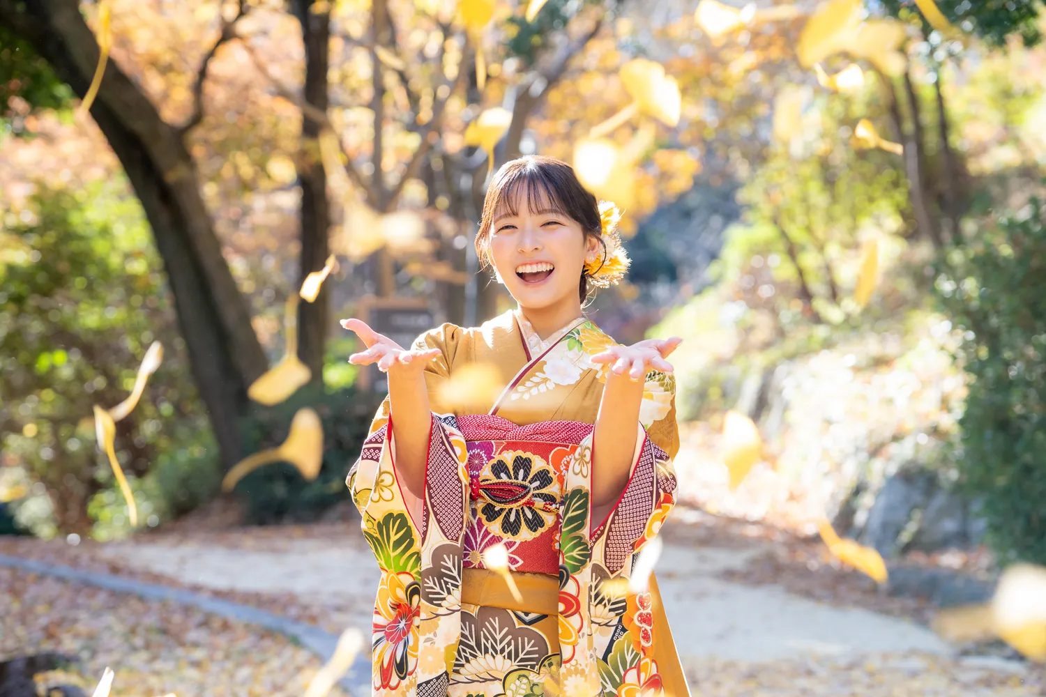 浜松城公園で、いちょうの葉が舞う中で笑顔の振袖姿
