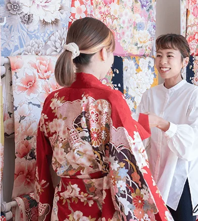 スタッフと振袖を試着する女性