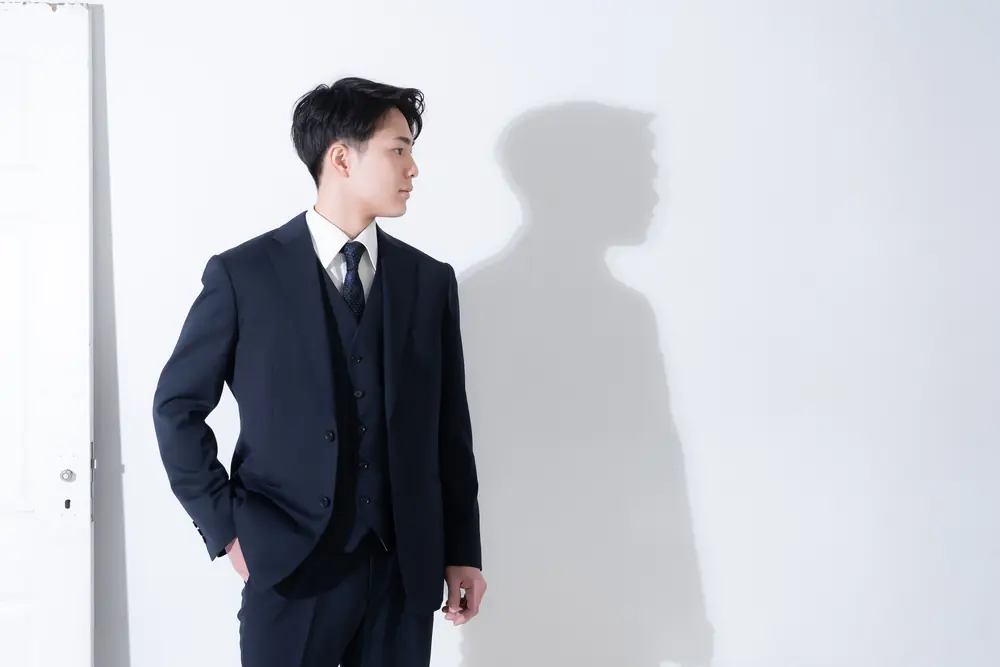スーツ姿で横を向く男性