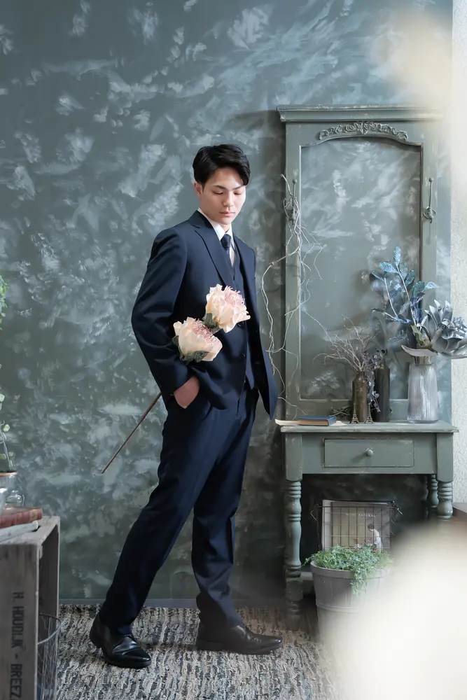 花束を持つスーツ姿の男性