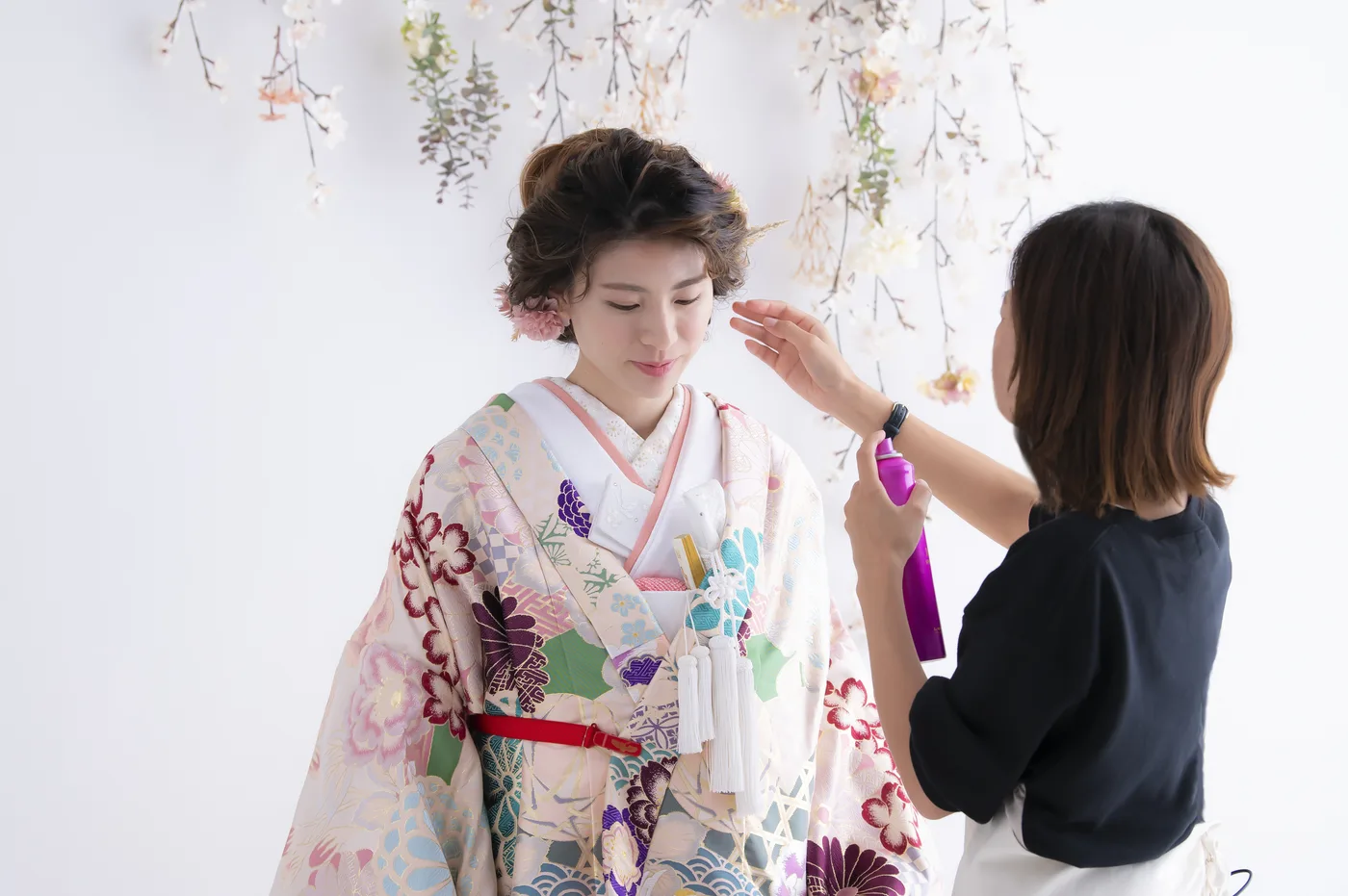 色打掛の花嫁の髪を整えるスタイリスト