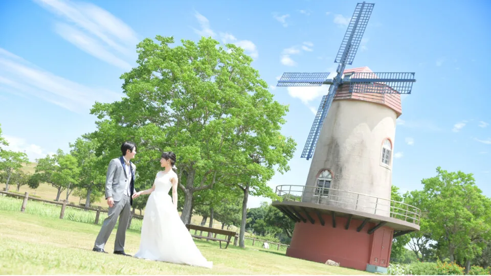 風車の前を歩く新郎新婦