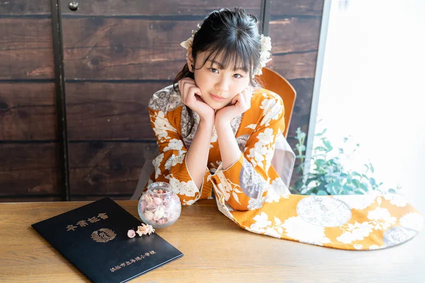 卒業証書を前に頬杖をつく卒業袴の女の子